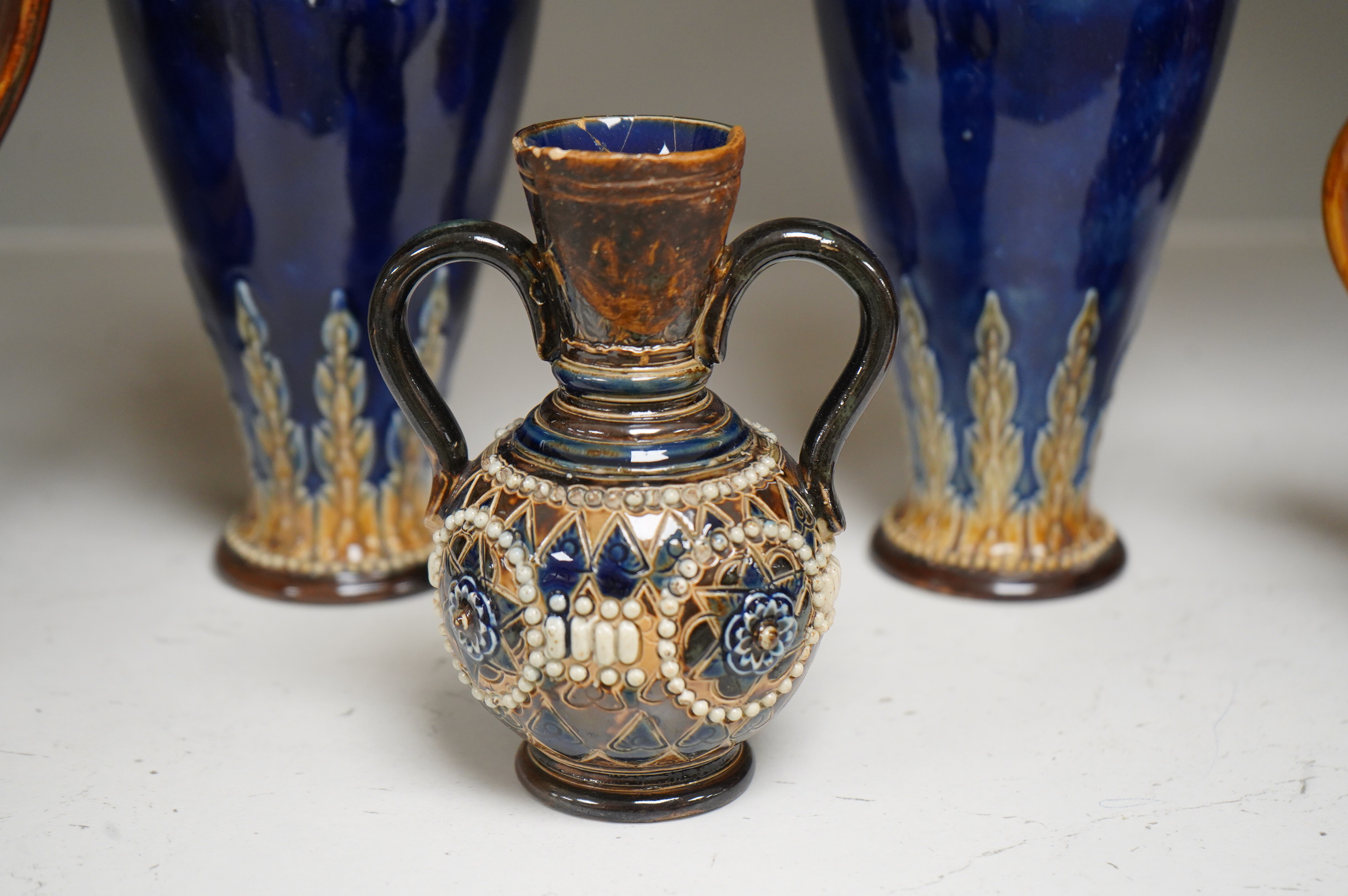 A Doulton Lambeth stoneware commemorative pitcher of William Ewart Gladstone 23cm high, together with a pair of vases two handled vase and a mug, (5).